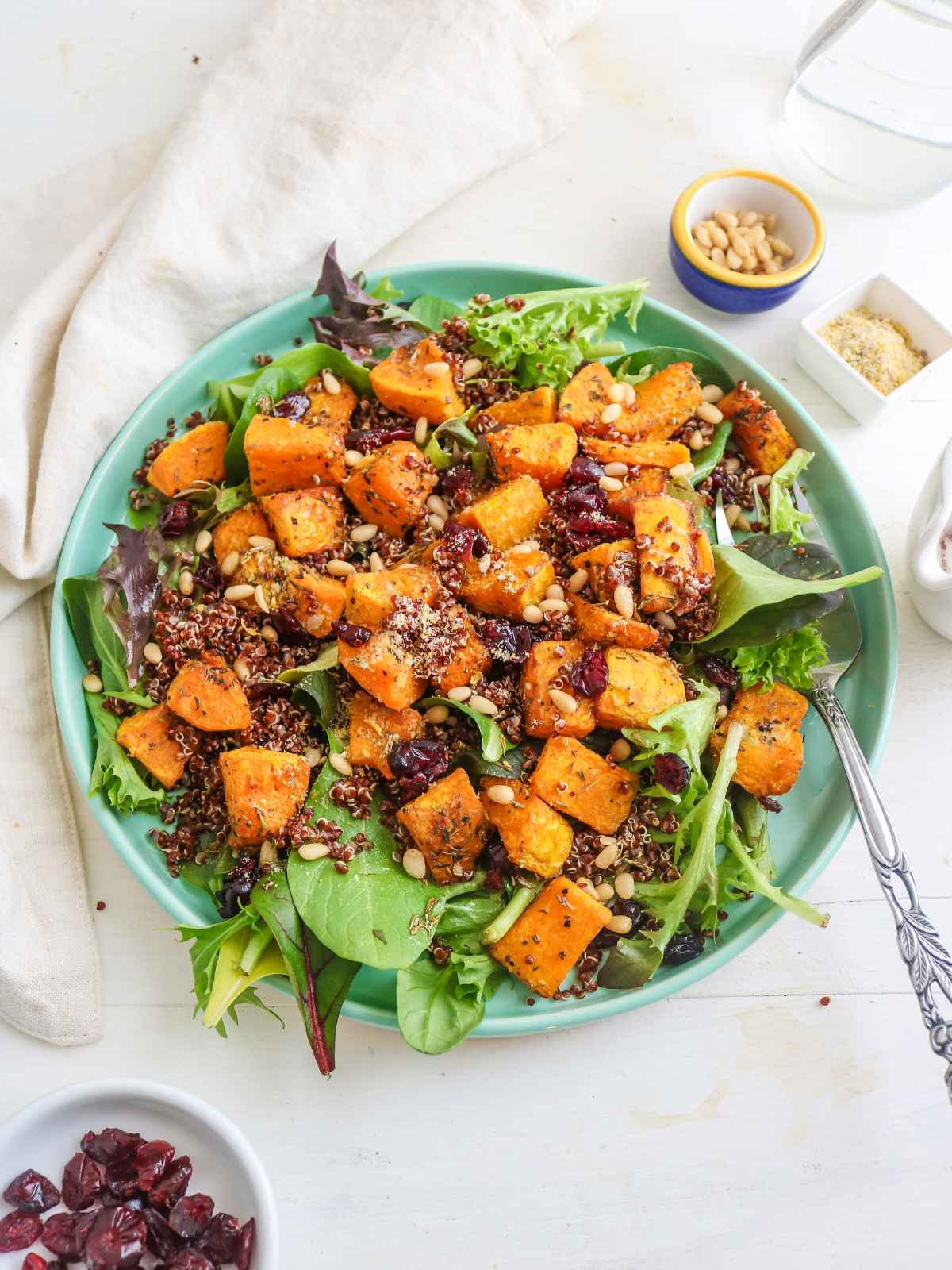 Butternut squash and quinoa salad served in a round green color plate.