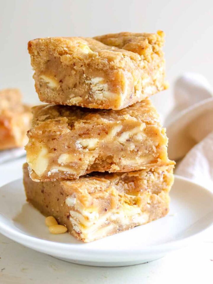 eggless blondies stacked on a white plate
