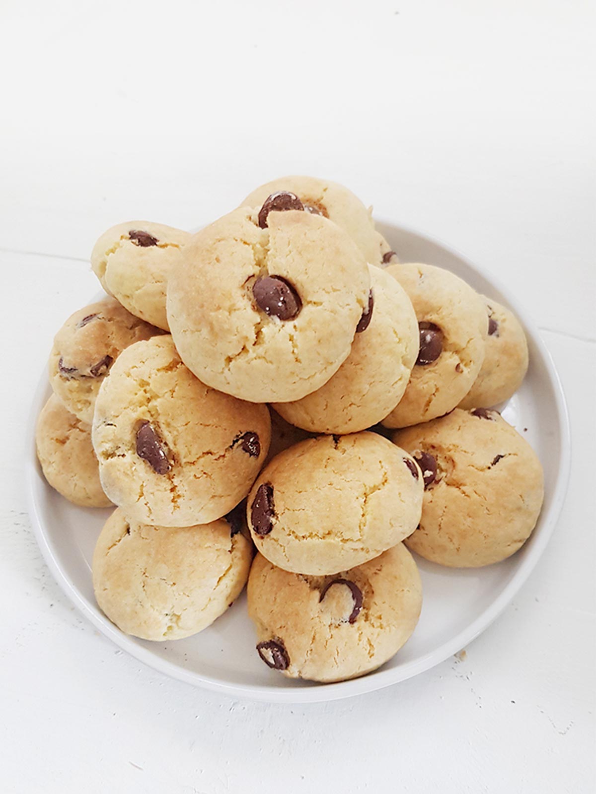 Eggless chocolate chip cookies pile on a plate