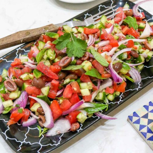 Mediterranean Cucumber Tomato Salad served in a black plate.