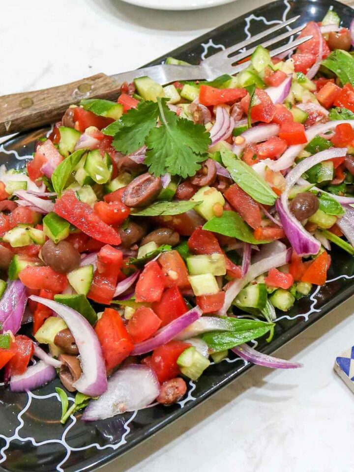 Mediterranean Cucumber Tomato Salad served in a black plate.
