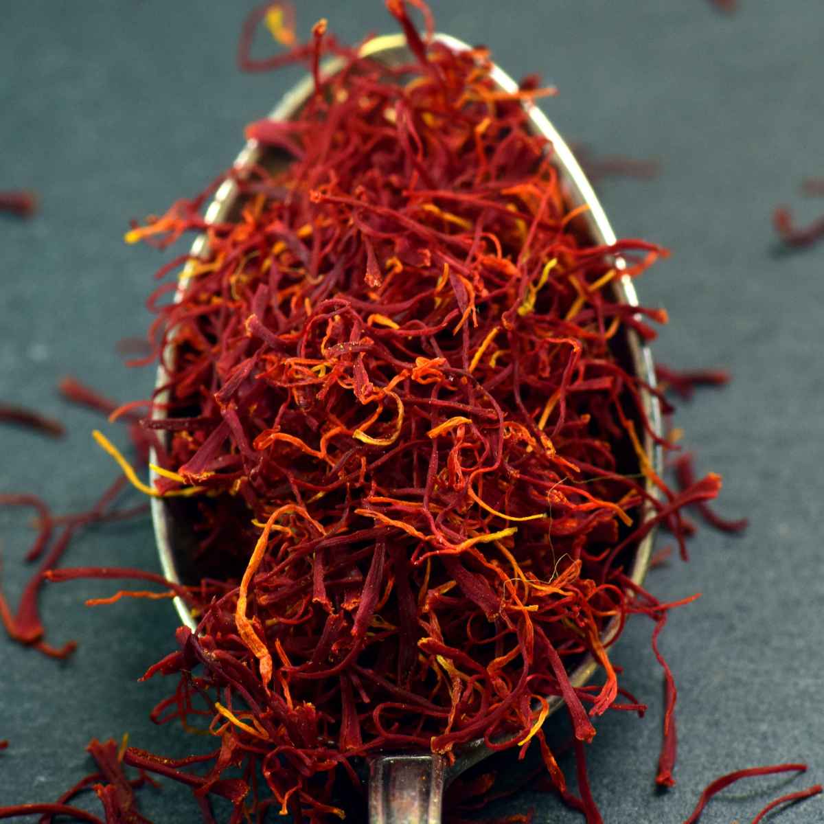 Saffron strings placed in a metal spoon.