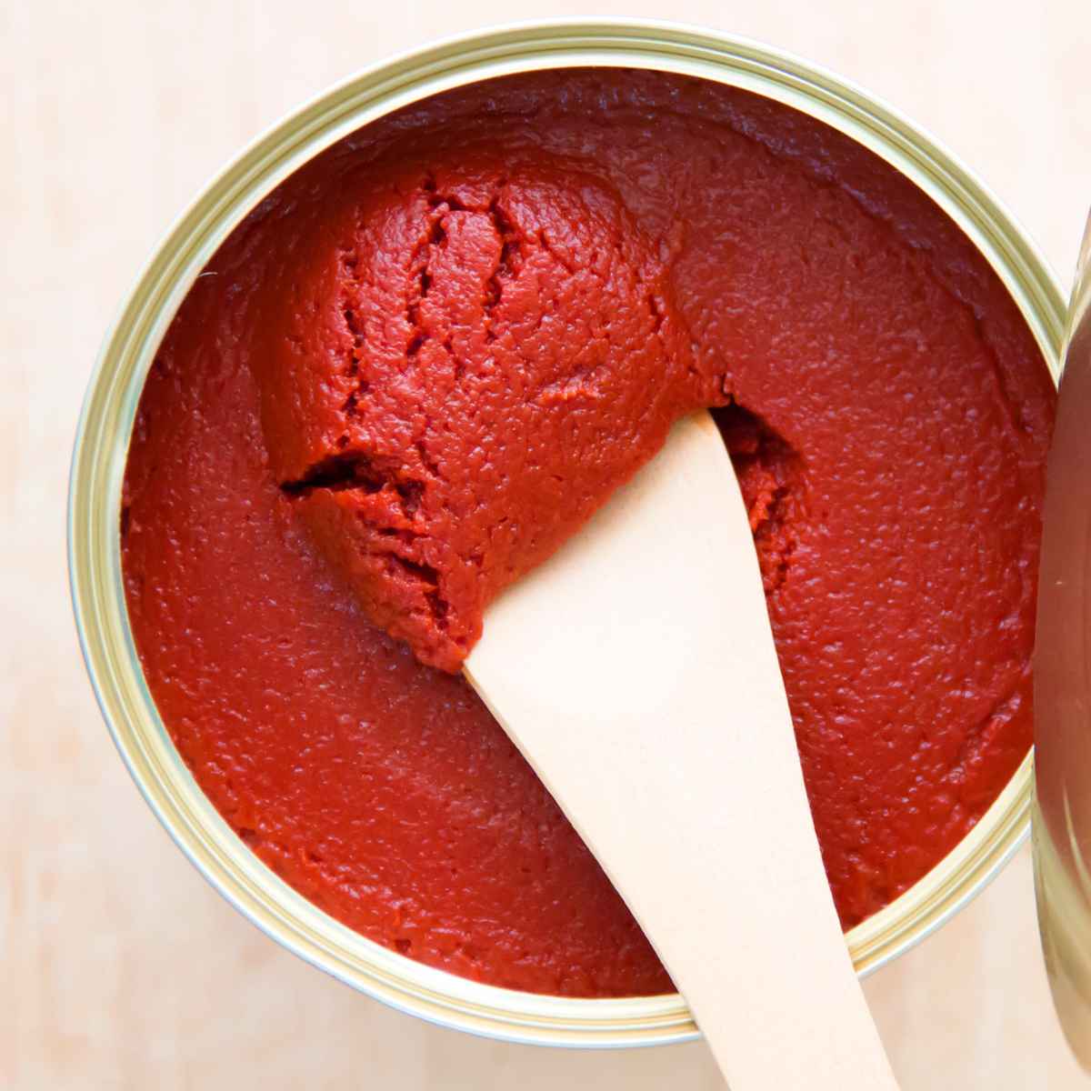 Tomato paste can and a wooden spatula on top.