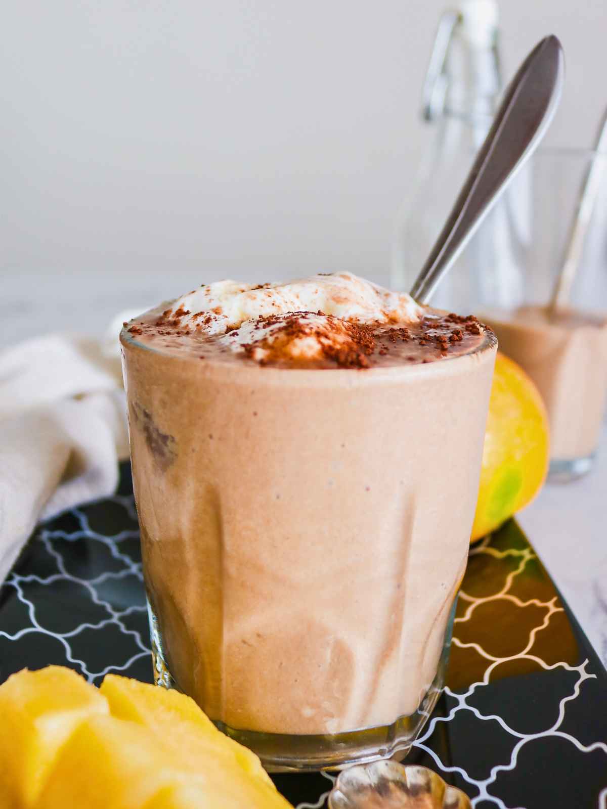 Smoothie glass placed on a black tray.