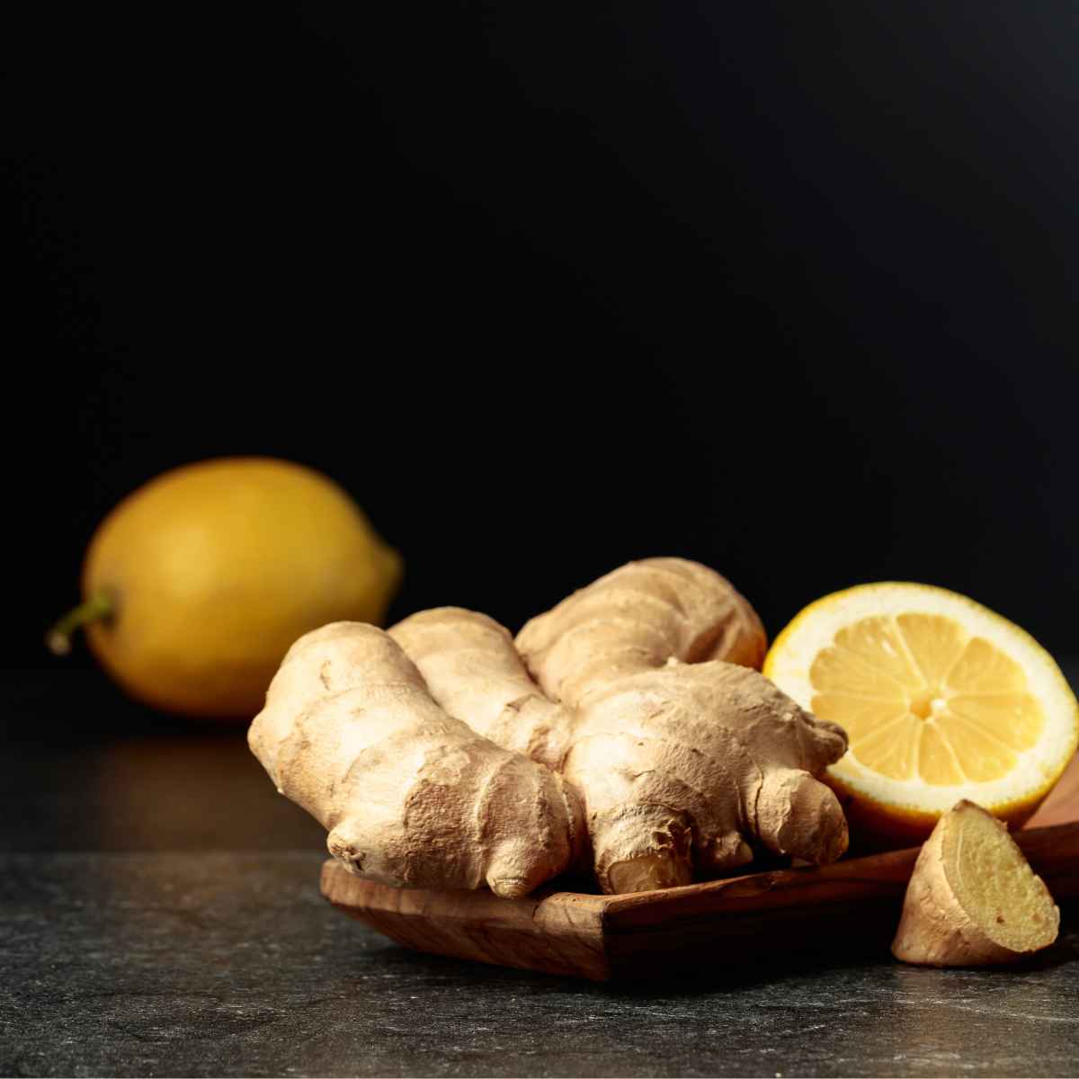 Lemon and ginger placed in a wooden tray.