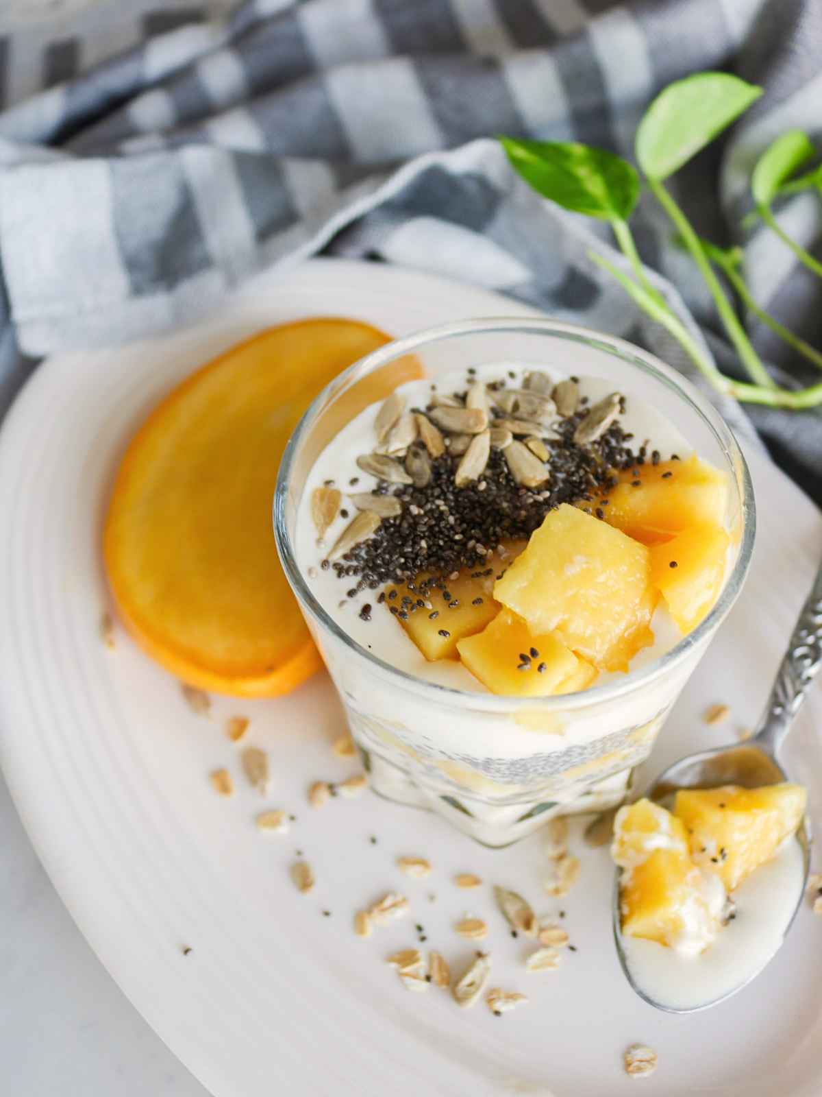 Overnight oats served in a glass jar topped with mango and chia seeds.
