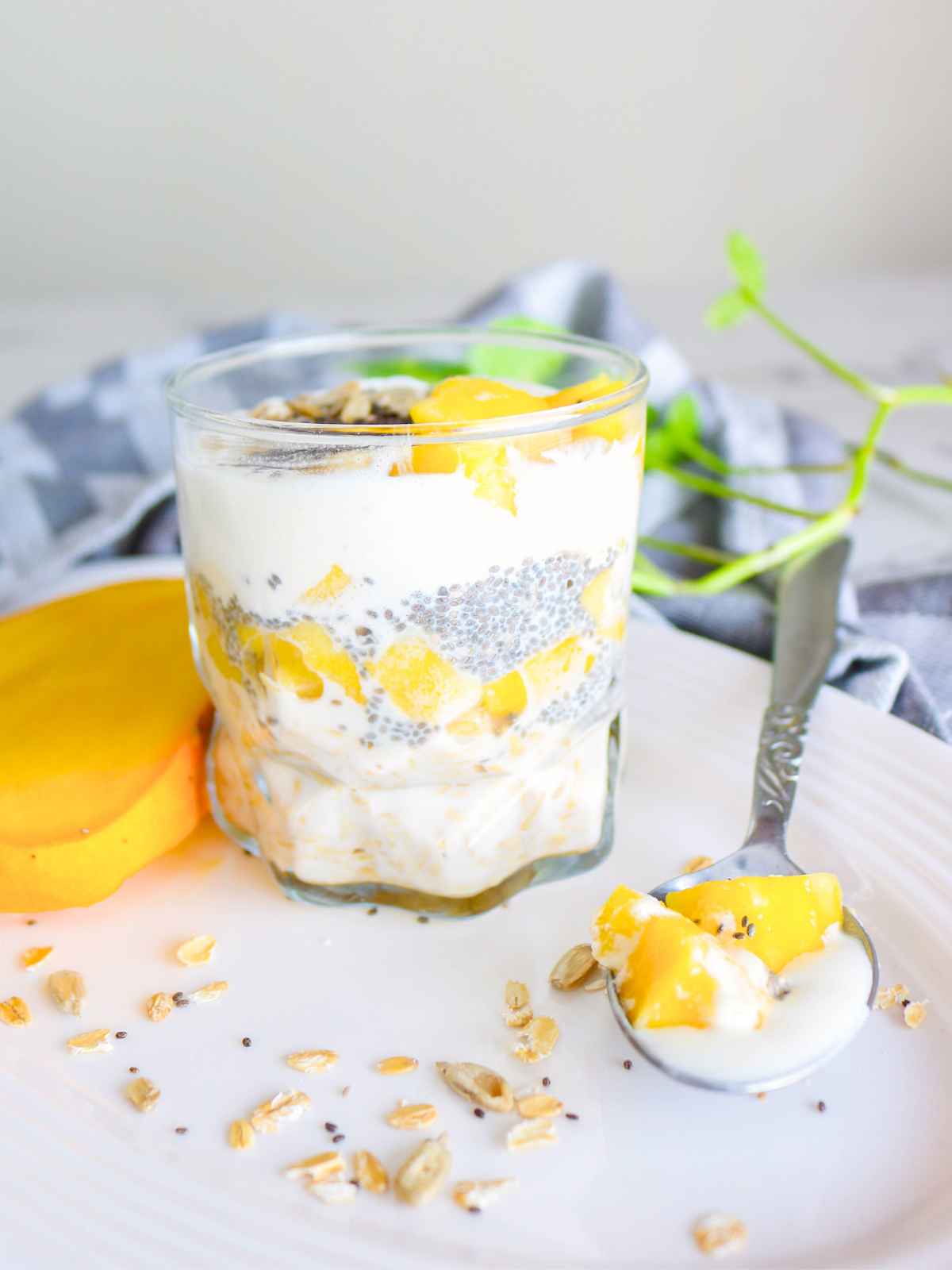 Side view of glass jar filled with mango overnight oats.