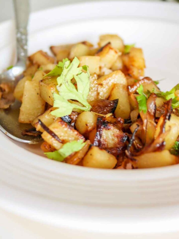 onions and potatoes served on a white plate.