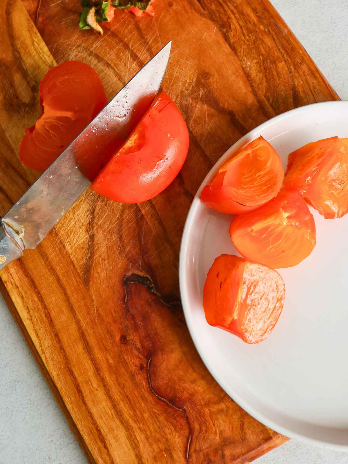 Slicing persimmon on a wooden borad.