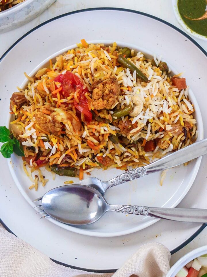 vegan biryani served in a plate with fork and spoon
