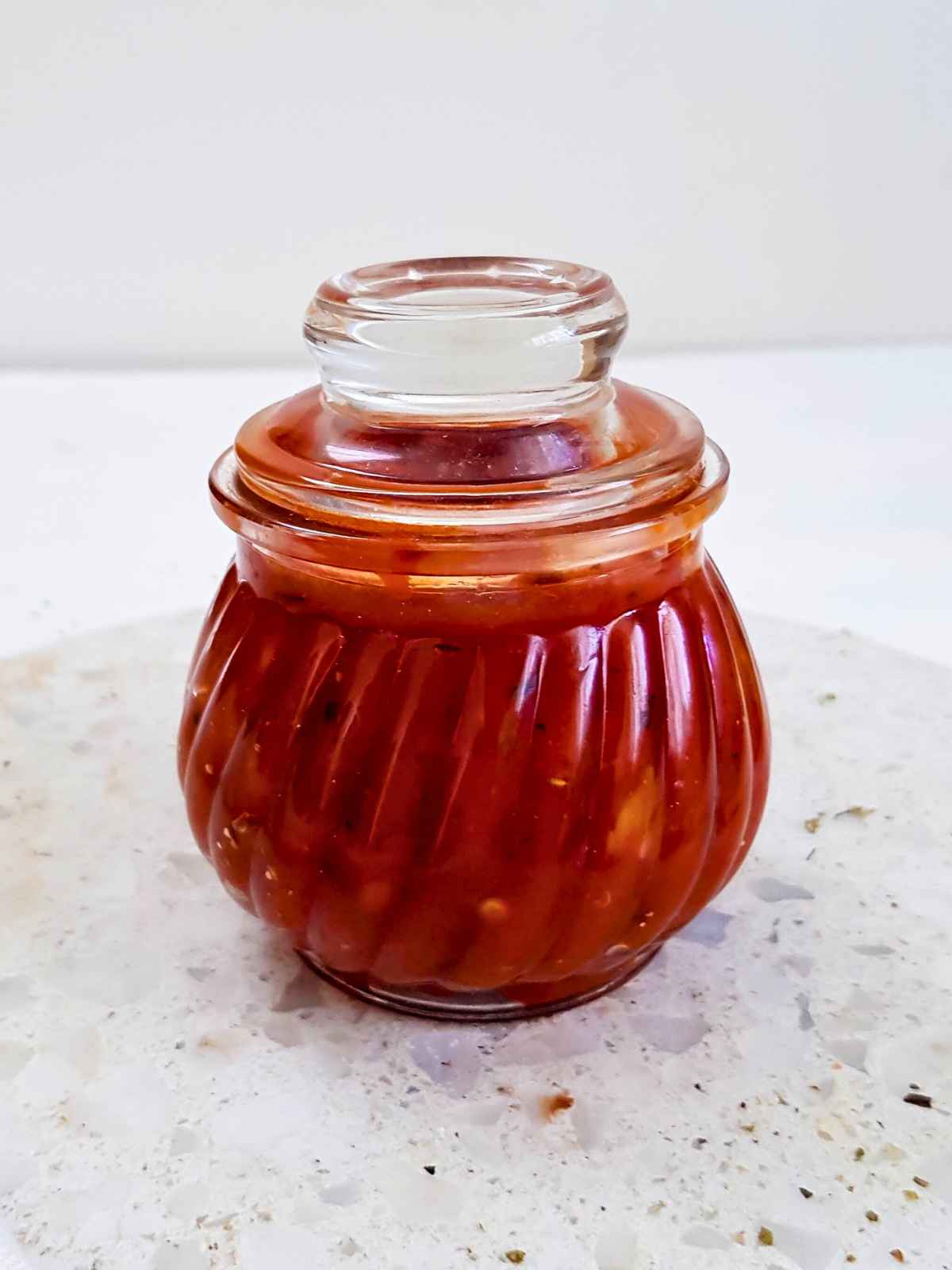 Storing vegan pizza sauce in airtight glass jar.